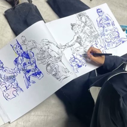 Ilustraciones de luchadores mexicanos en cuaderno durante activación creativa de lucha libre en Arena Qro